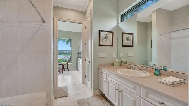 a spacious bathroom with a granite countertop sink a mirror and a bathtub