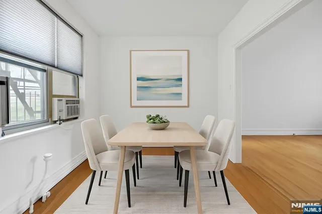 a view of a dining room with furniture a rug and wooden floor