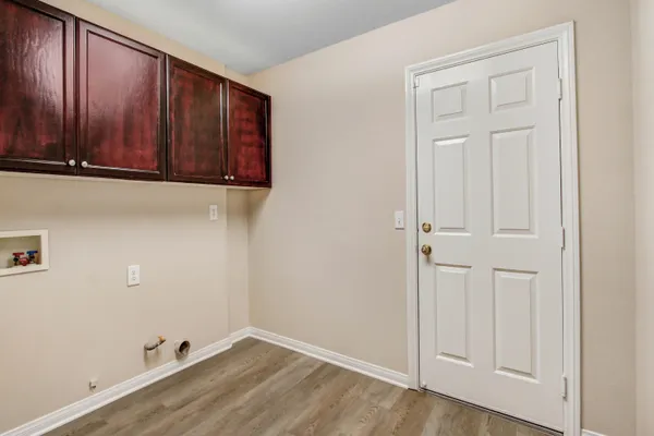 an empty room with wooden floor and cabinet