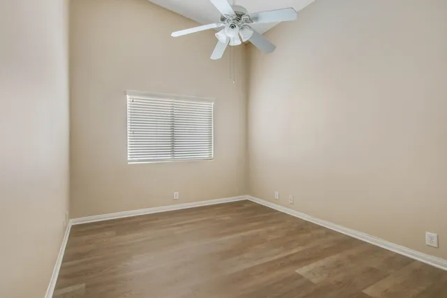 an empty room with a window and a fan