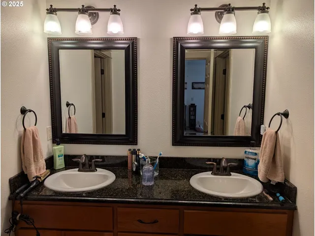 a bathroom with double vanity sinks and a mirror