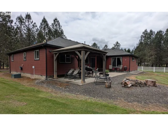 a backyard of a house with table and chairs