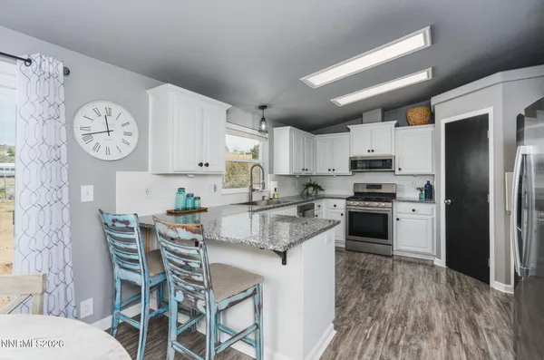 a kitchen with stainless steel appliances granite countertop a refrigerator sink and cabinets