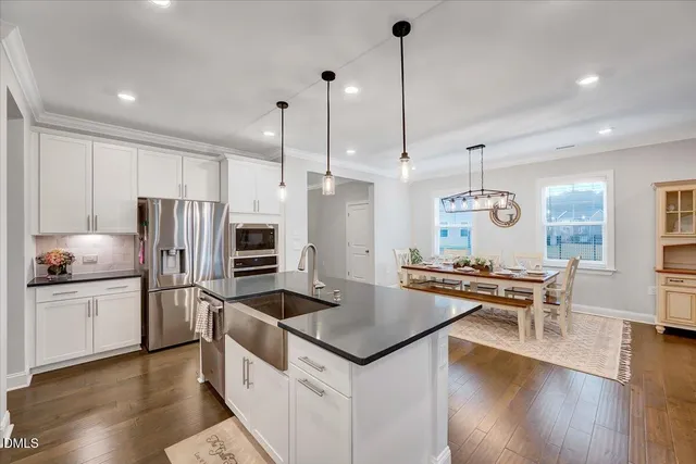 a kitchen with kitchen island granite countertop wooden floor cabinets and stainless steel appliances