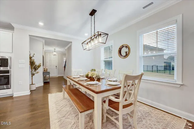 a living room with a table and kitchen view