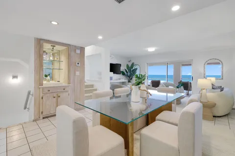 a living room with furniture a flat screen tv and kitchen view