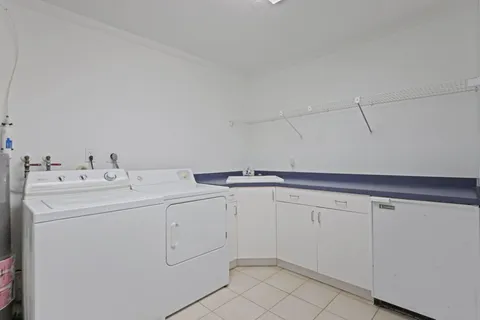 a utility room with cabinets washer and dryer