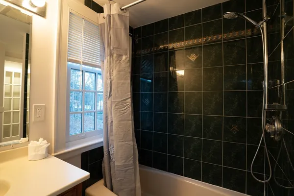 a bathroom with a sink mirror and shower