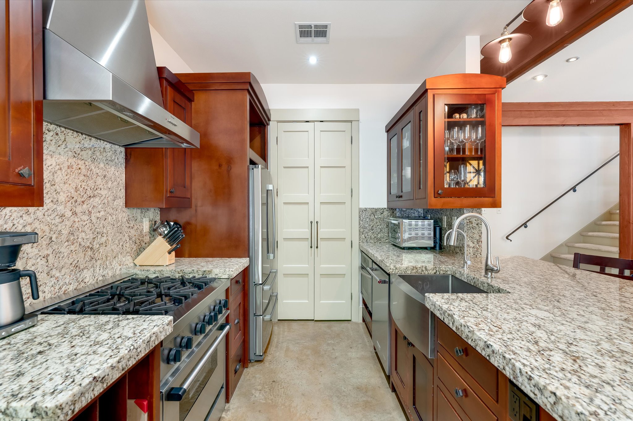 2405 Kinney Road, Unit 2405 Austin, TX 78704 - Photo 4 of 15 Galley kitchen with granite countertops, 36" commercial range, stainless steel appliances, pantry and SS farmhouse sink