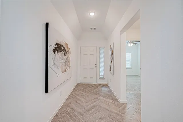 a view of a hallway with wooden floor and stairs