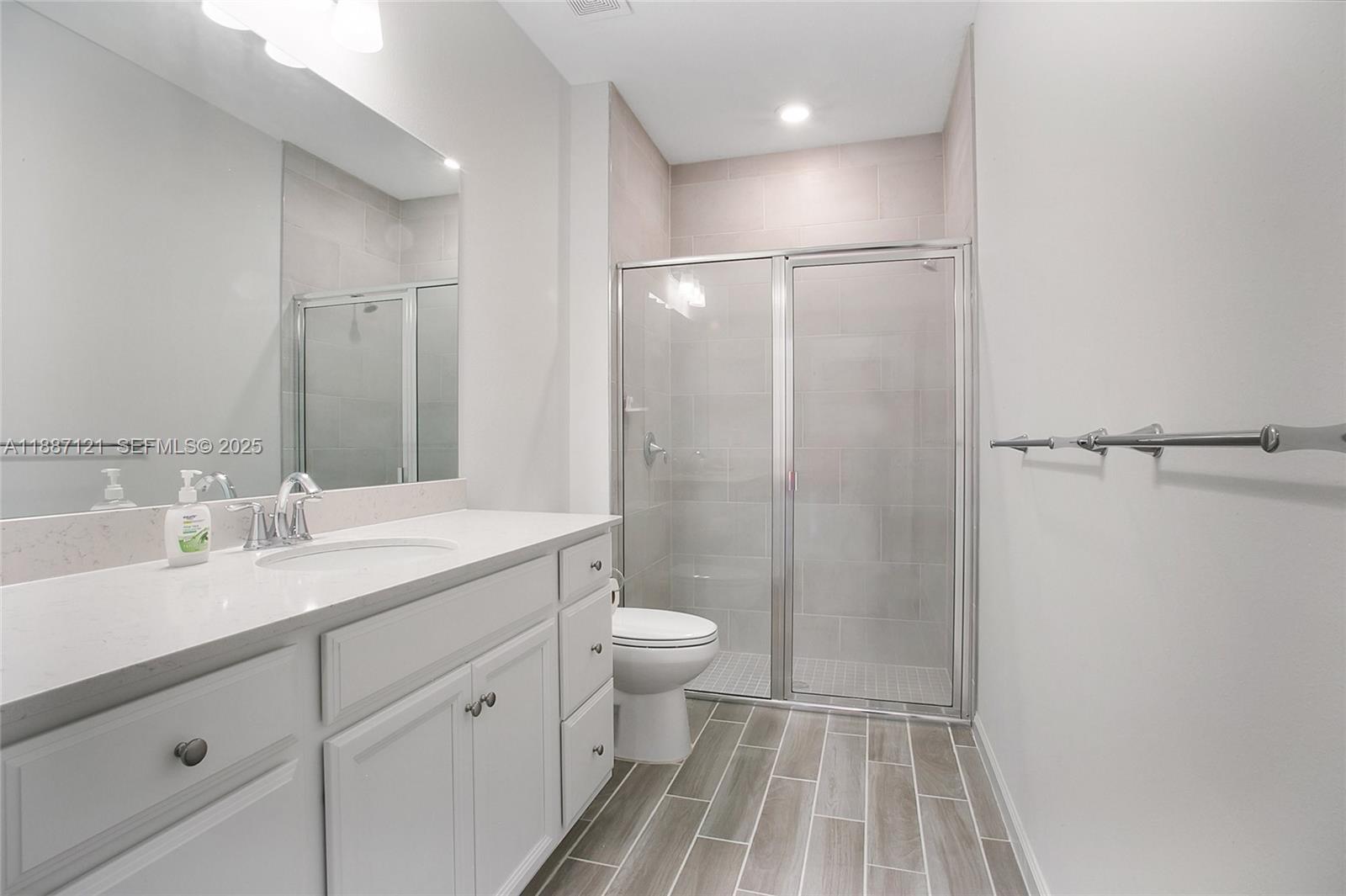 7796 Southwest 74th Loop Ocala, FL 34481 - Photo 12 of 20 a bathroom with a sink a toilet a shower and a mirror