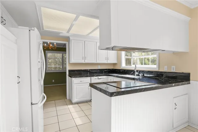 a kitchen with granite countertop a sink stove and cabinets