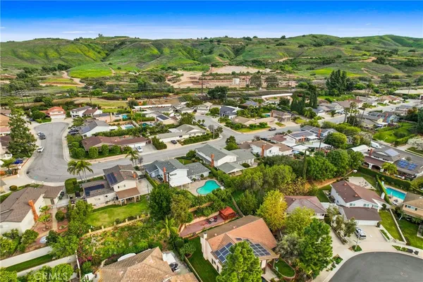 an aerial view of residential houses with outdoor space and trees