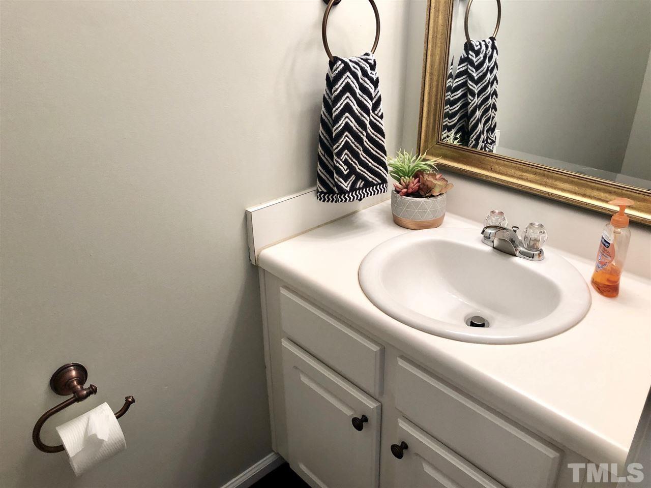 8126 Rhiannon Road Raleigh, NC 27613 - Photo 12 of 24 a bathroom with a sink and a mirror