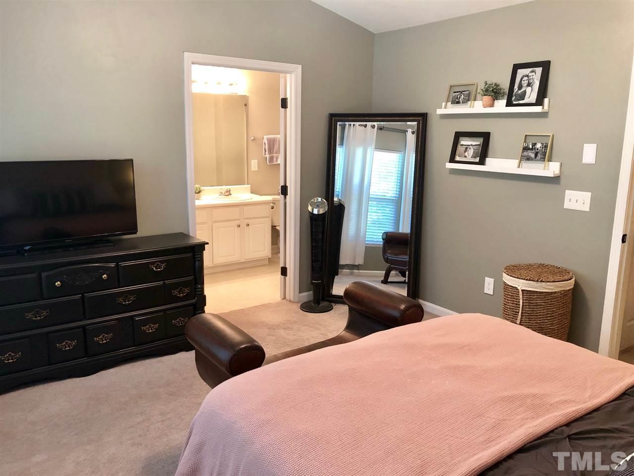8126 Rhiannon Road Raleigh, NC 27613 - Photo 16 of 24 a bedroom with a bed and a flat screen tv