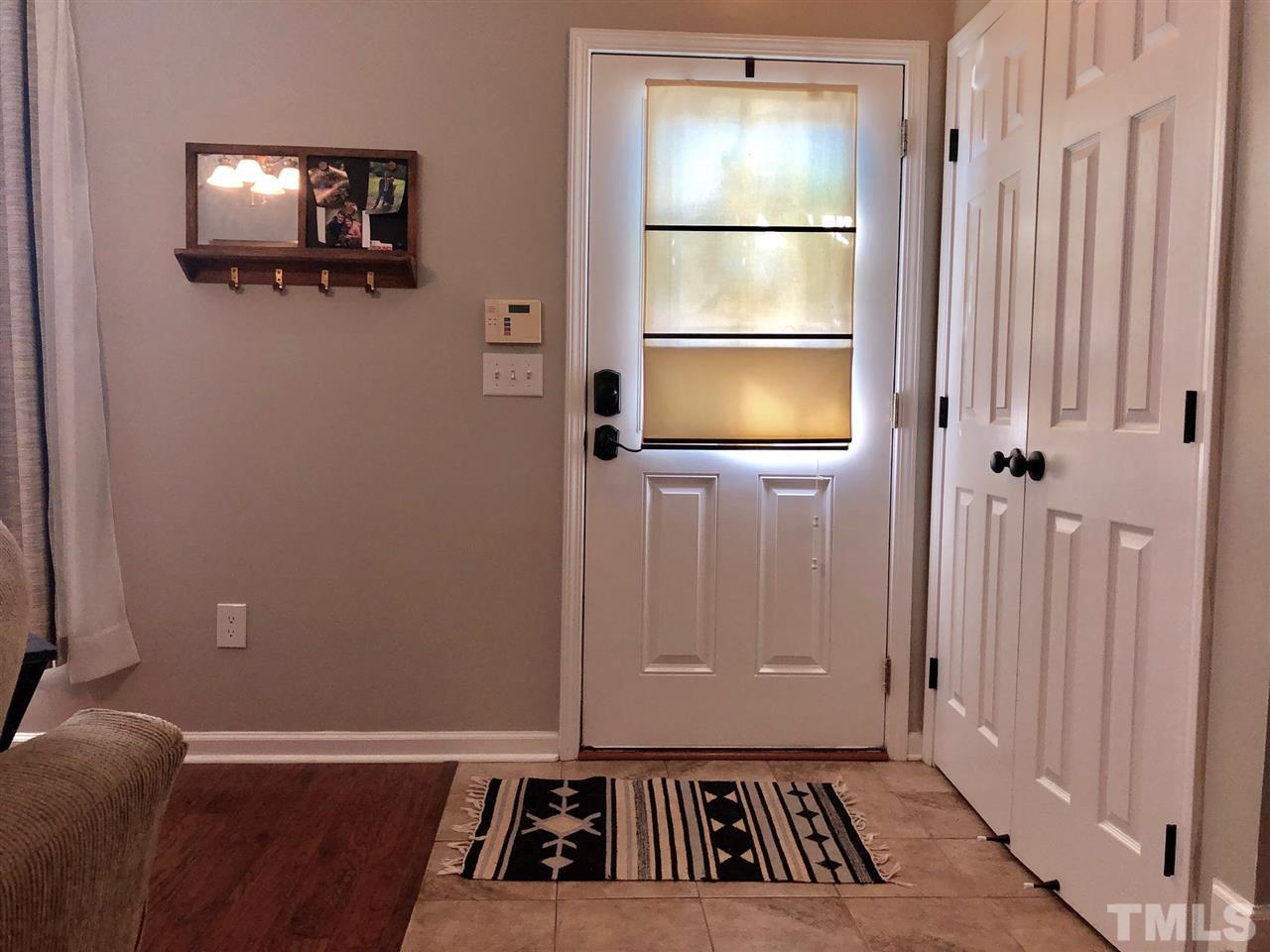 8126 Rhiannon Road Raleigh, NC 27613 - Photo 3 of 24 a view of a livingroom with wooden floor and a flat screen tv