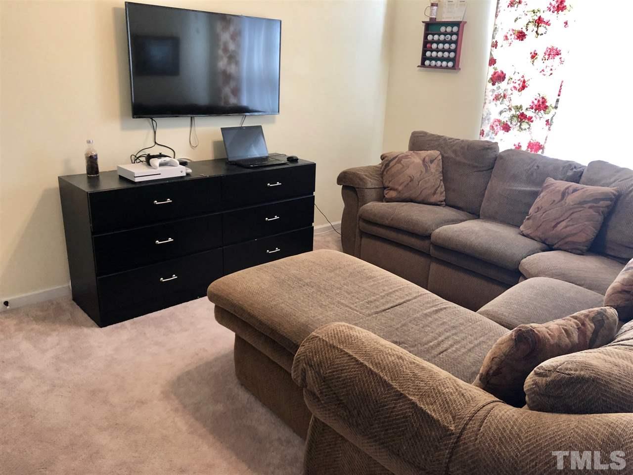 8126 Rhiannon Road Raleigh, NC 27613 - Photo 22 of 24 a living room with furniture and a flat screen tv