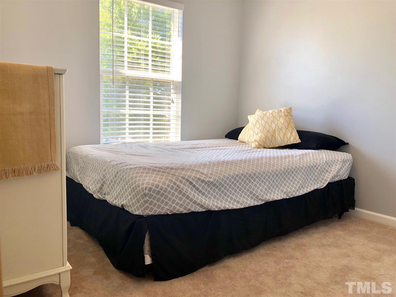 8126 Rhiannon Road Raleigh, NC 27613 - Photo 23 of 24 a bed sitting in a bedroom next to a window
