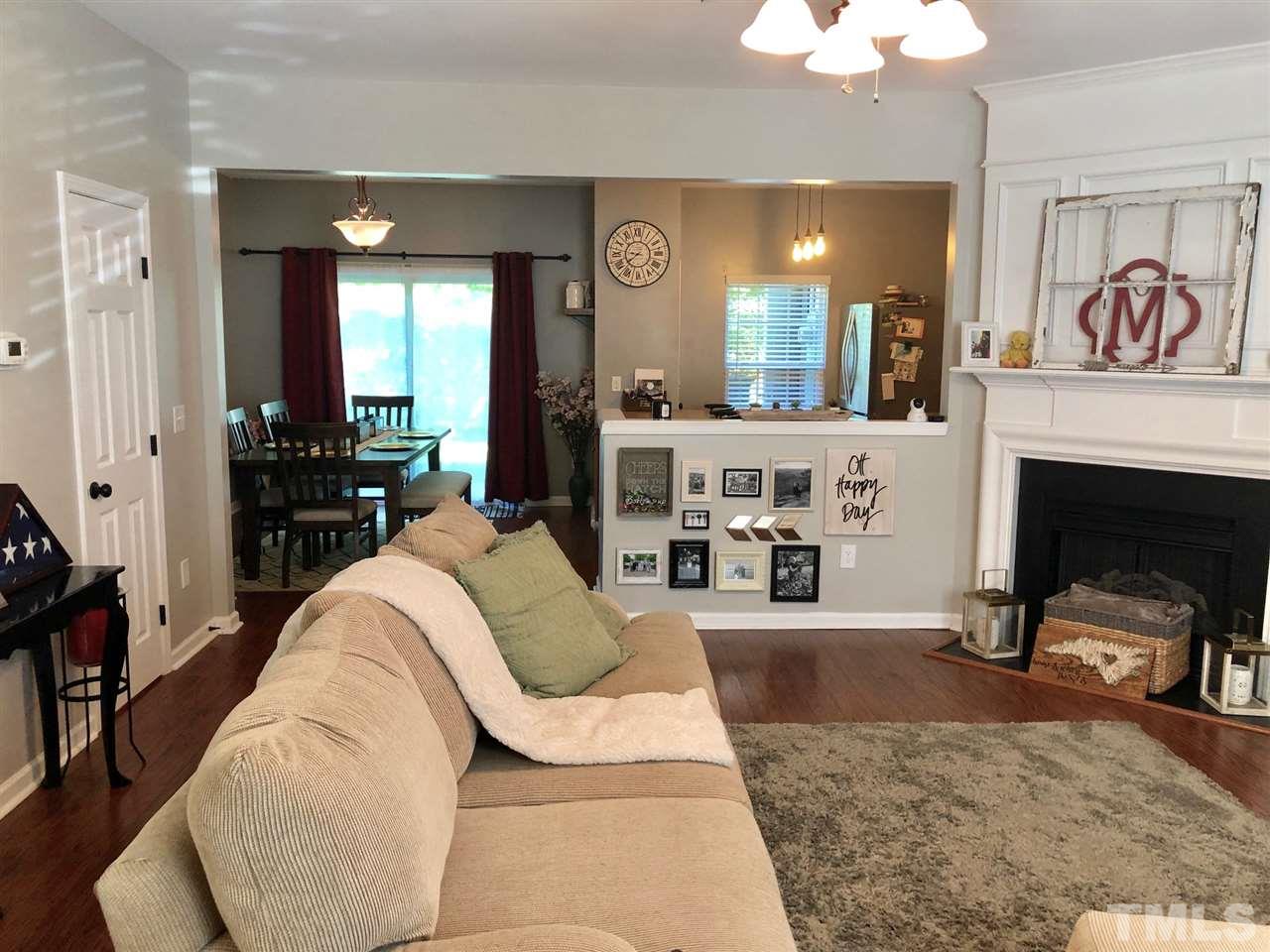 8126 Rhiannon Road Raleigh, NC 27613 - Photo 5 of 24 a living room with furniture a dining table and a fireplace