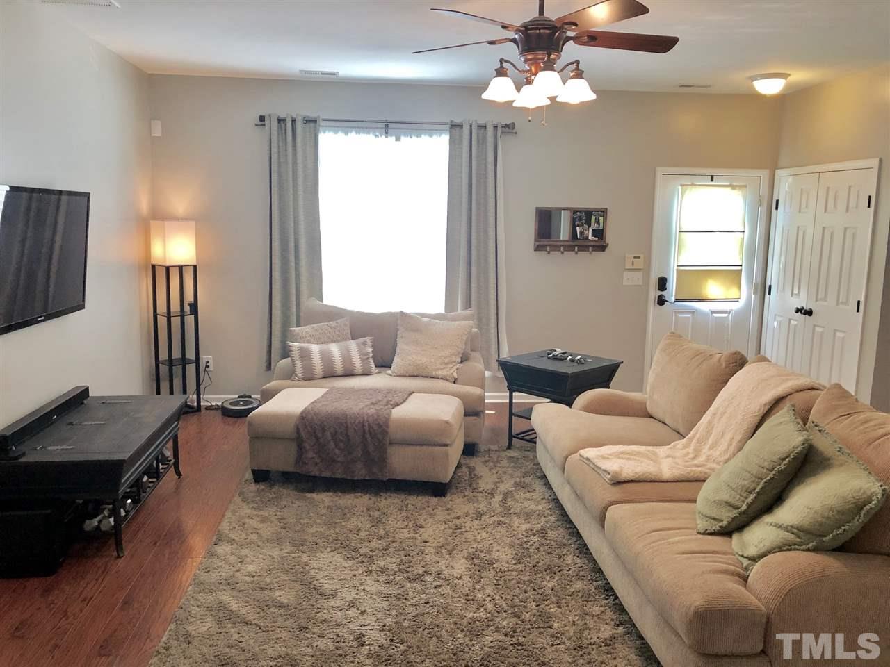 8126 Rhiannon Road Raleigh, NC 27613 - Photo 6 of 24 a spacious bedroom with a bed a couch and a chandelier