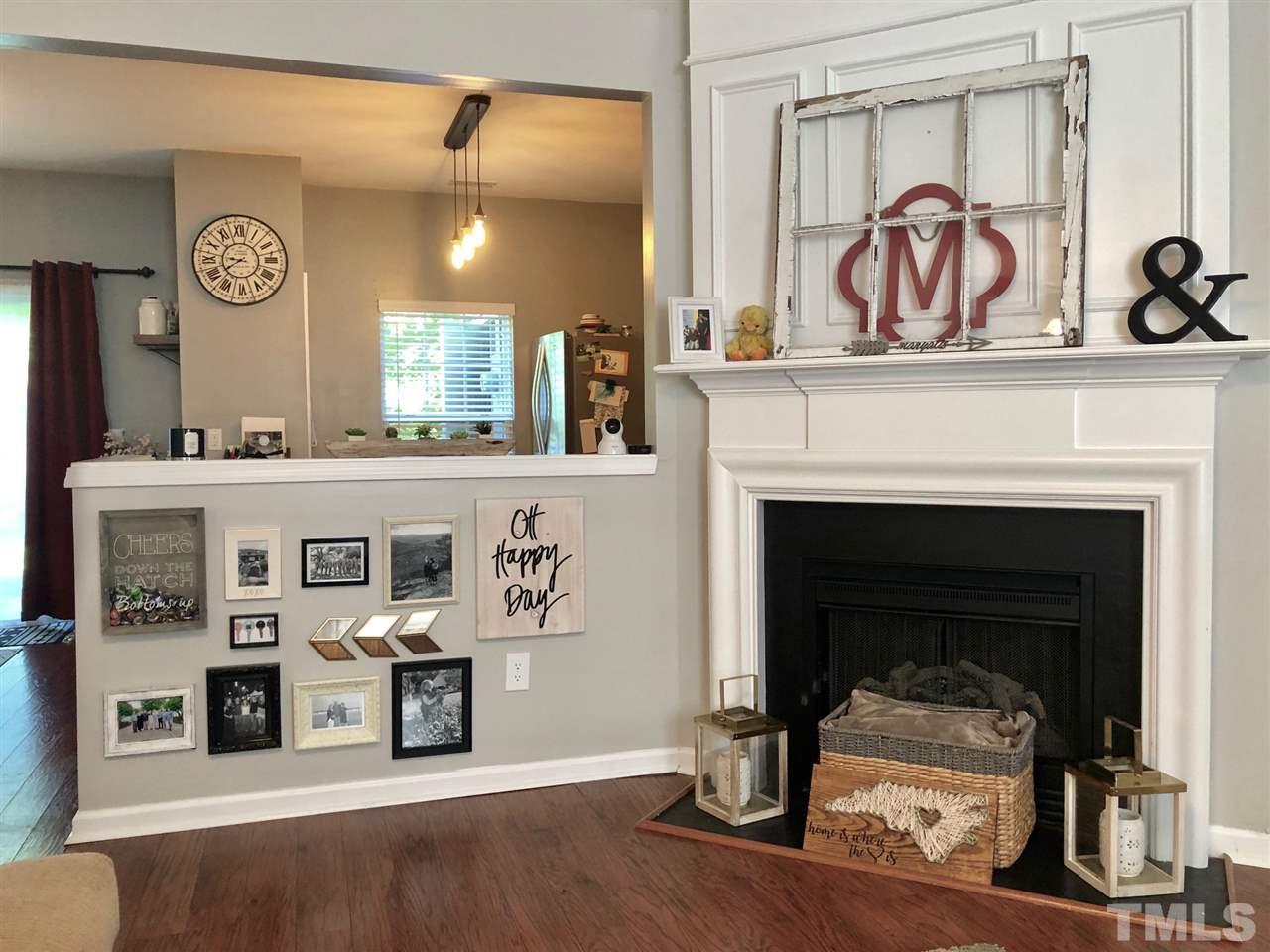 8126 Rhiannon Road Raleigh, NC 27613 - Photo 7 of 24 a living room with stainless steel appliances kitchen island a table and a fireplace