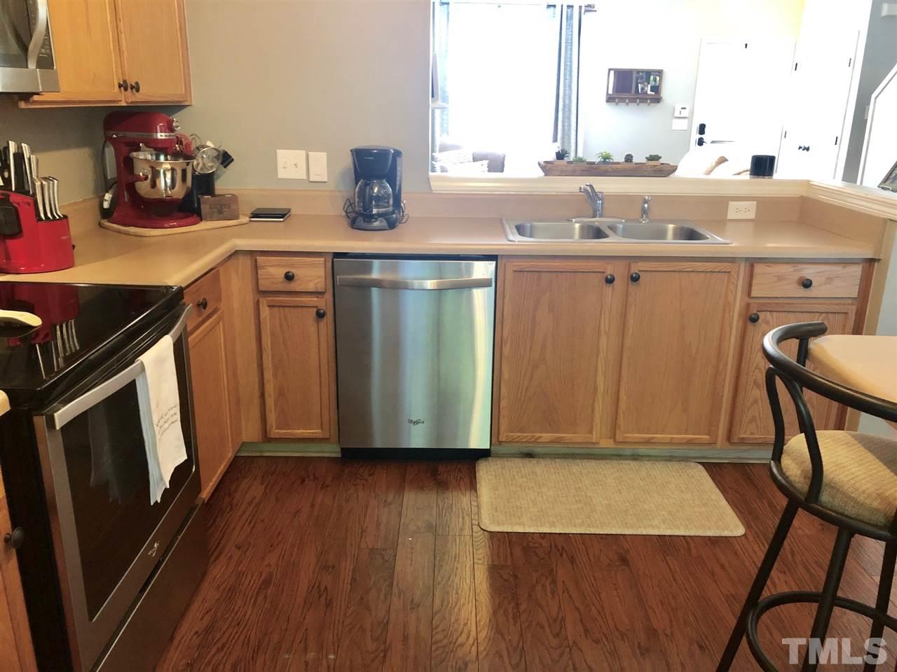 8126 Rhiannon Road Raleigh, NC 27613 - Photo 10 of 24 a kitchen with a sink a microwave a stove and cabinets
