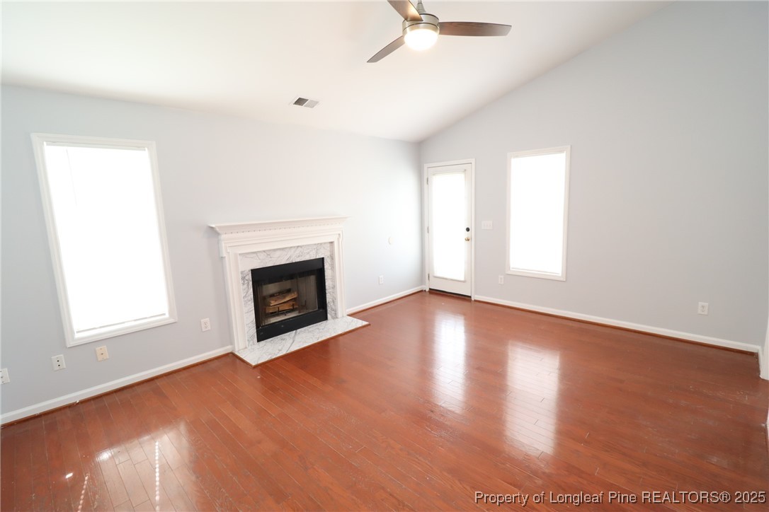 4105 Scofield Drive Raleigh, NC 27610 - Photo 12 of 27 an empty room with wooden floor fireplace and windows
