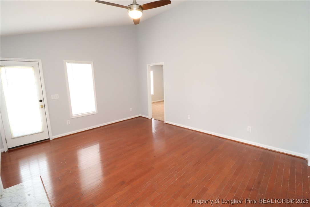 4105 Scofield Drive Raleigh, NC 27610 - Photo 9 of 27 an empty room with wooden floor cabinet and windows