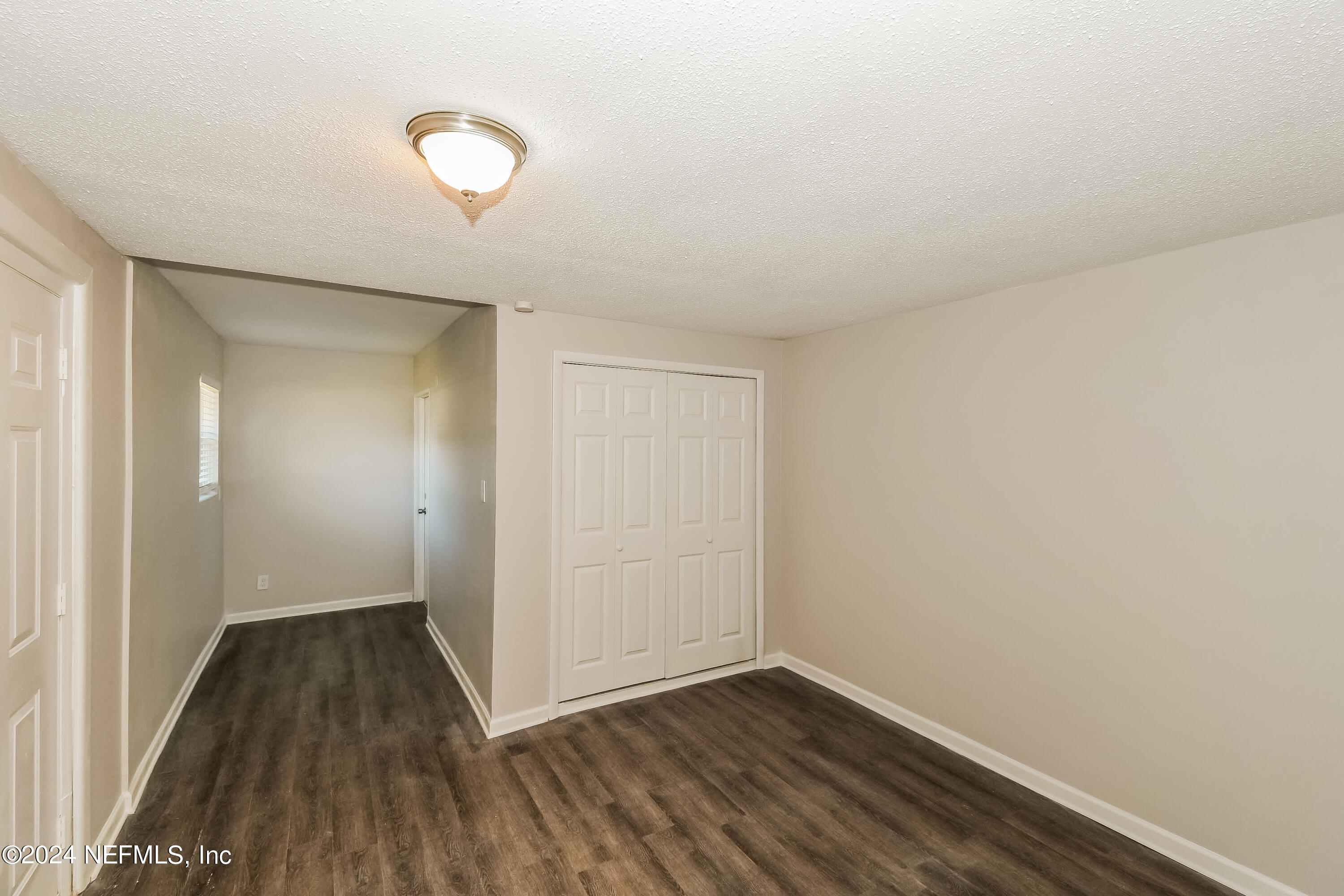 7070 Perke Drive Jacksonville, FL 32210 - Photo 11 of 16 a view of a room with wooden floor and white walls