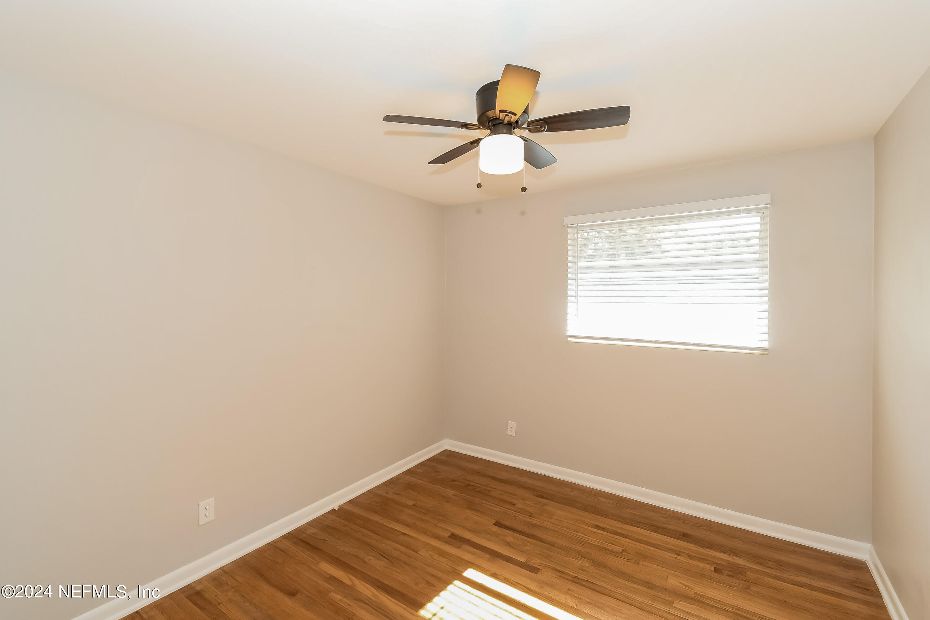 7070 Perke Drive Jacksonville, FL 32210 - Photo 12 of 16 a view of a room with wooden floor and a ceiling fan