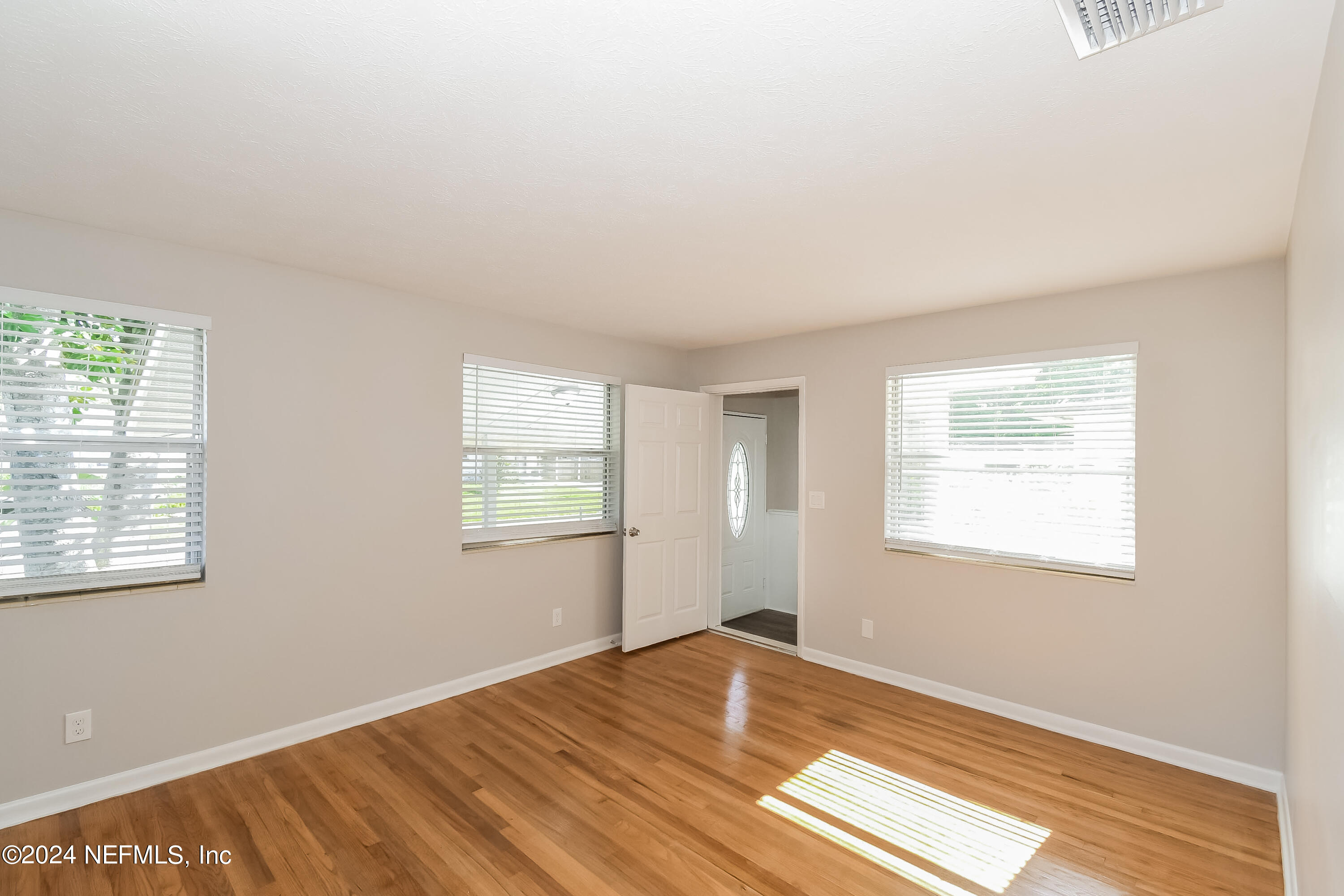7070 Perke Drive Jacksonville, FL 32210 - Photo 2 of 16 a view of a room with wooden floor and windows