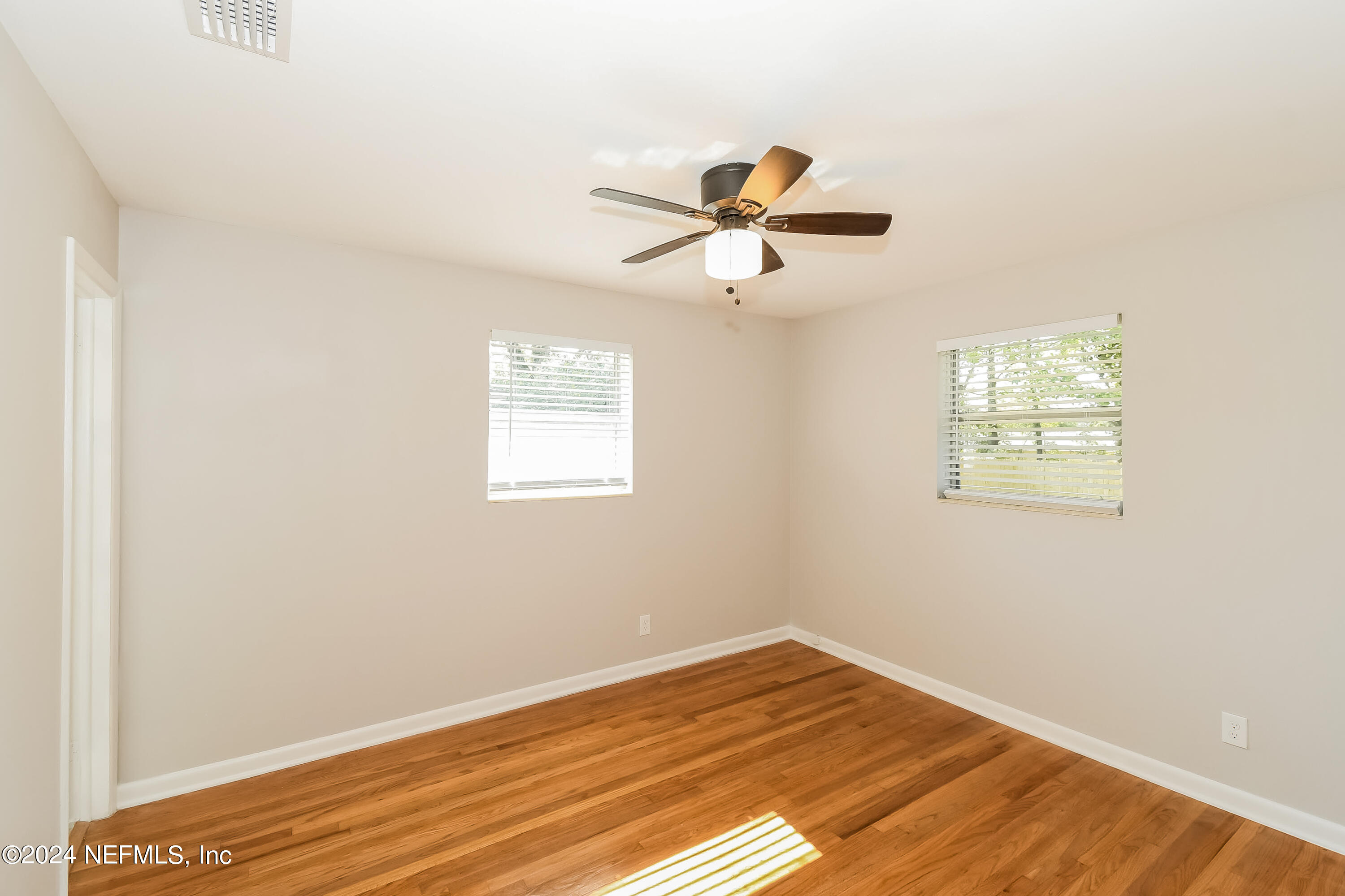 7070 Perke Drive Jacksonville, FL 32210 - Photo 7 of 16 a view of empty room with wooden floor and fan