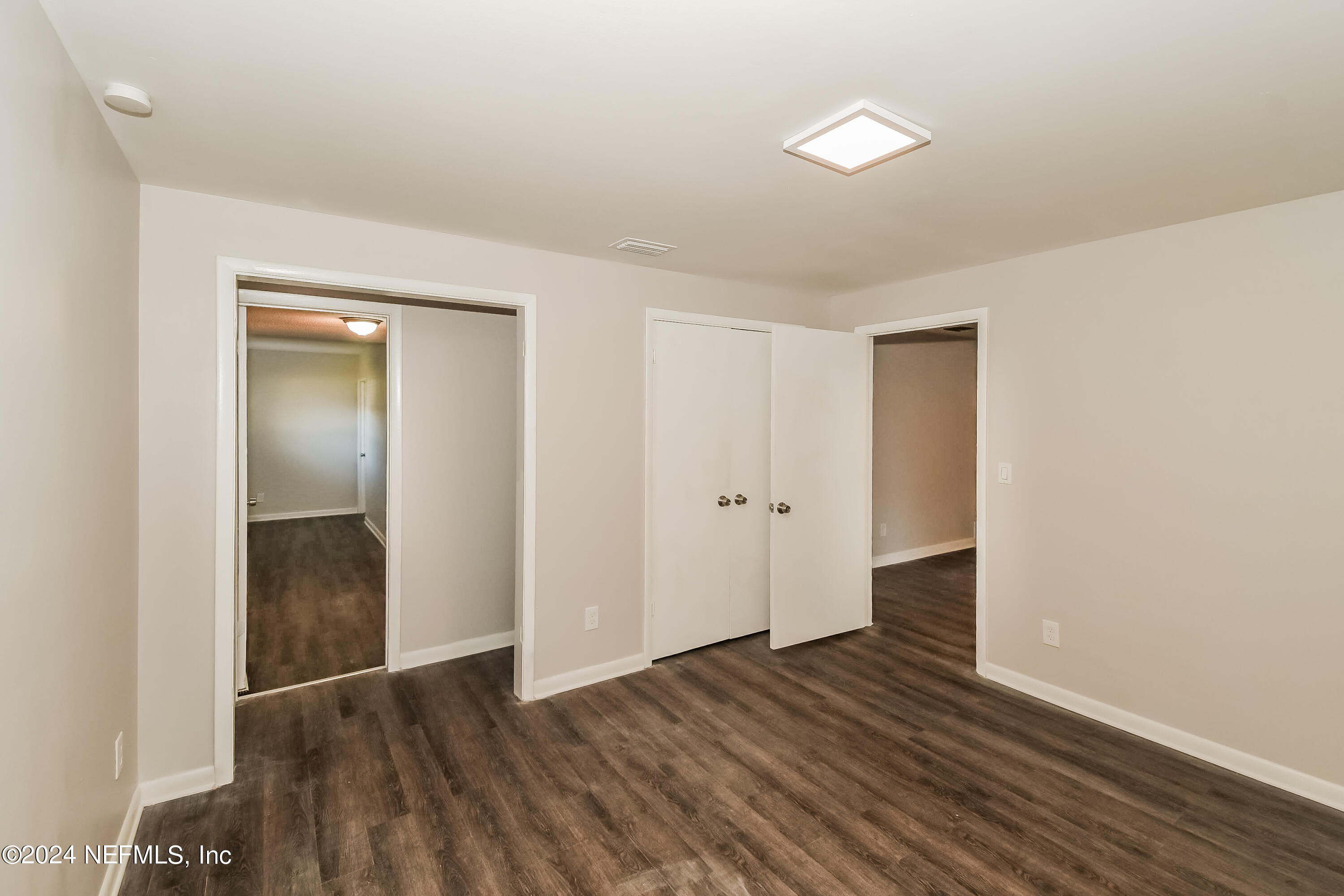 7070 Perke Drive Jacksonville, FL 32210 - Photo 10 of 16 a view of an empty room with wooden floor and closet