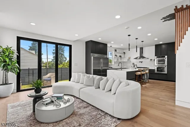 a living room with furniture and a dining table with kitchen view