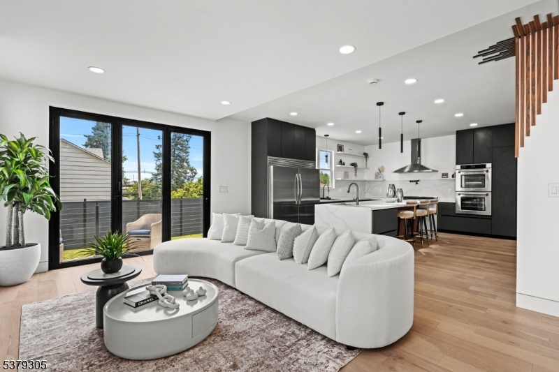 a living room with furniture and a dining table with kitchen view