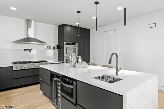 a kitchen with stainless steel appliances granite countertop a sink a stove and a refrigerator