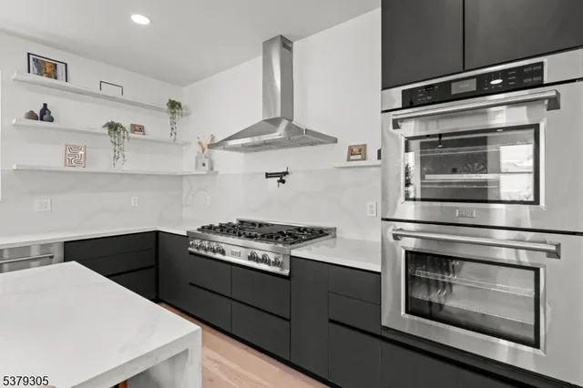 a kitchen with stainless steel appliances a stove and cabinets