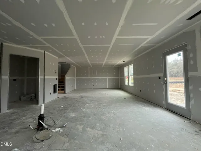 a white house with a big yard and large trees