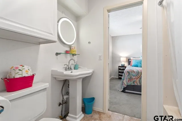 a bathroom with a sink toilet and a mirror