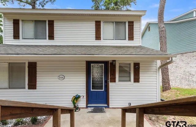 a view of a house with a door and wooden bench