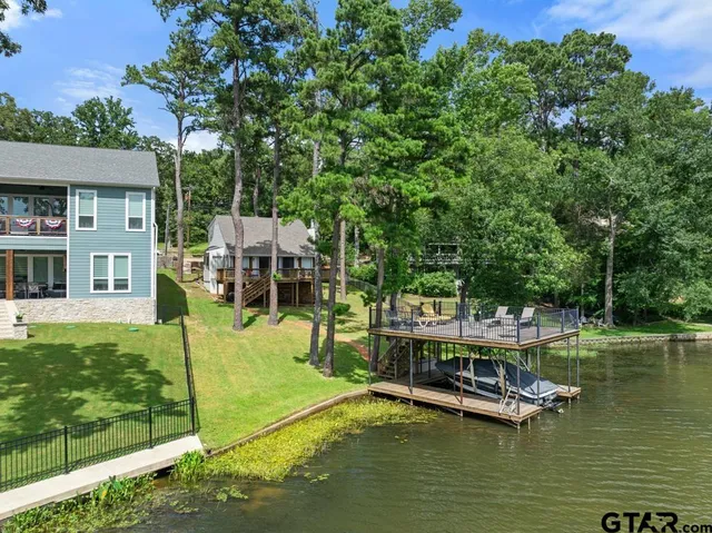 a view of a roof deck with lake and trees in the background
