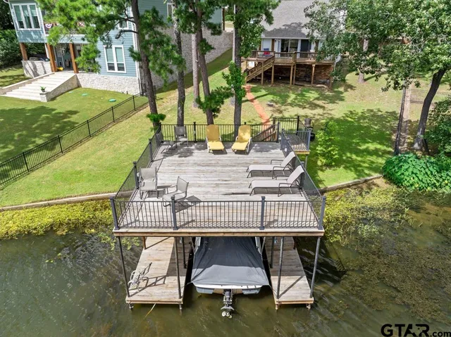 a view of a house with a wooden deck and a dining table