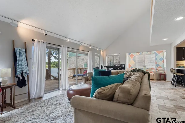 a living room with furniture floor to ceiling window and a flat screen tv