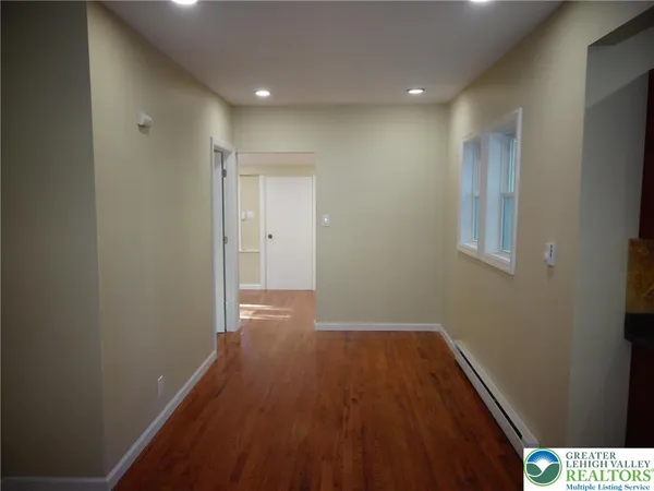 a view of a hallway with wooden floor