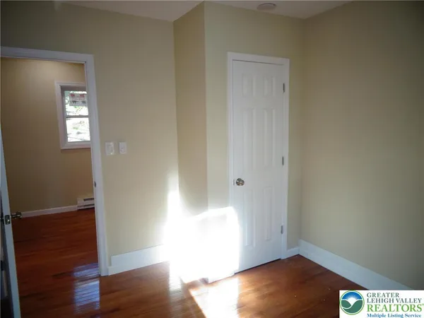 an empty room with wooden floor and closet