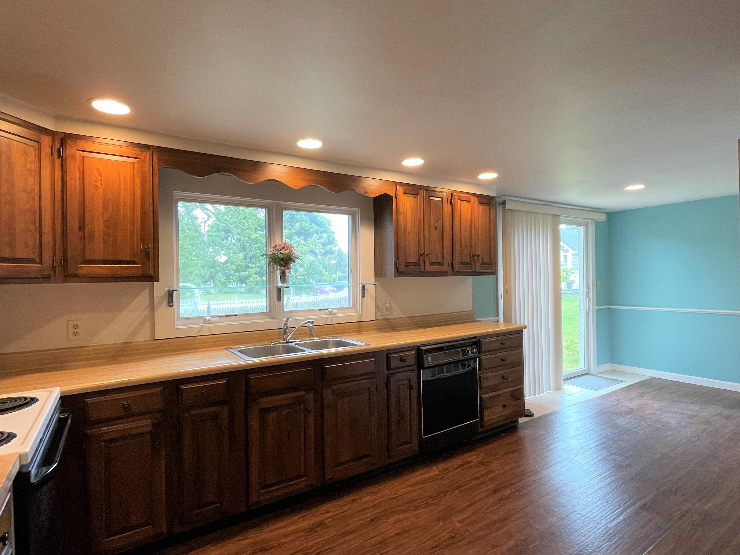 21 Long Road Harwich, MA 02645 - Photo 12 of 18 a large kitchen with stainless steel appliances granite countertop a sink and a large window