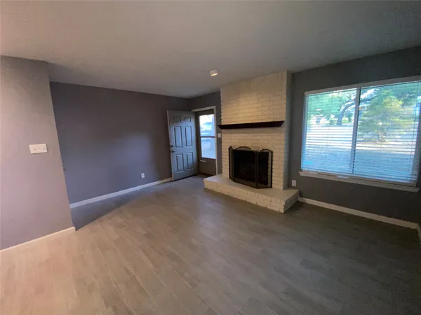 an empty room with fireplace and windows