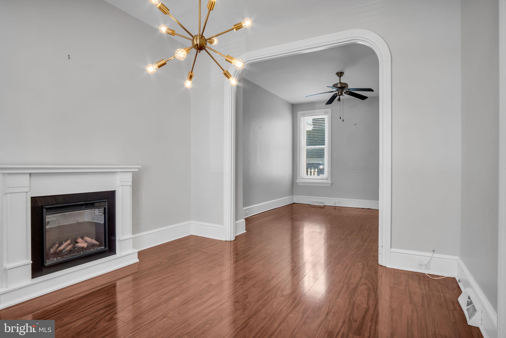211 Cumberland Street Harrisburg, PA 17102 - Photo 11 of 26 a view of an empty room with a fireplace and wooden floor