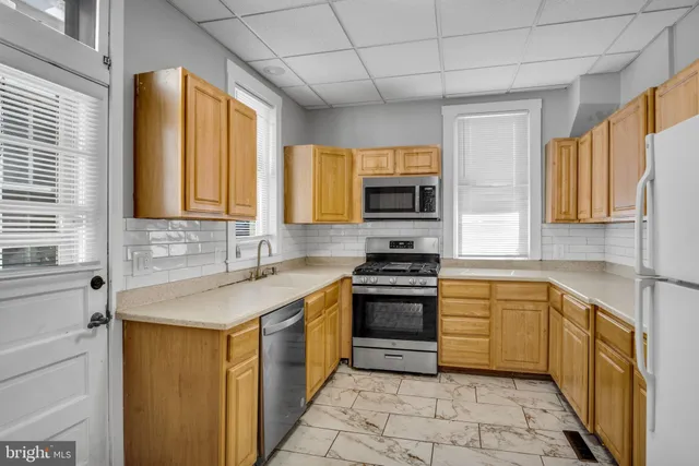 a kitchen with stainless steel appliances a stove sink and microwave