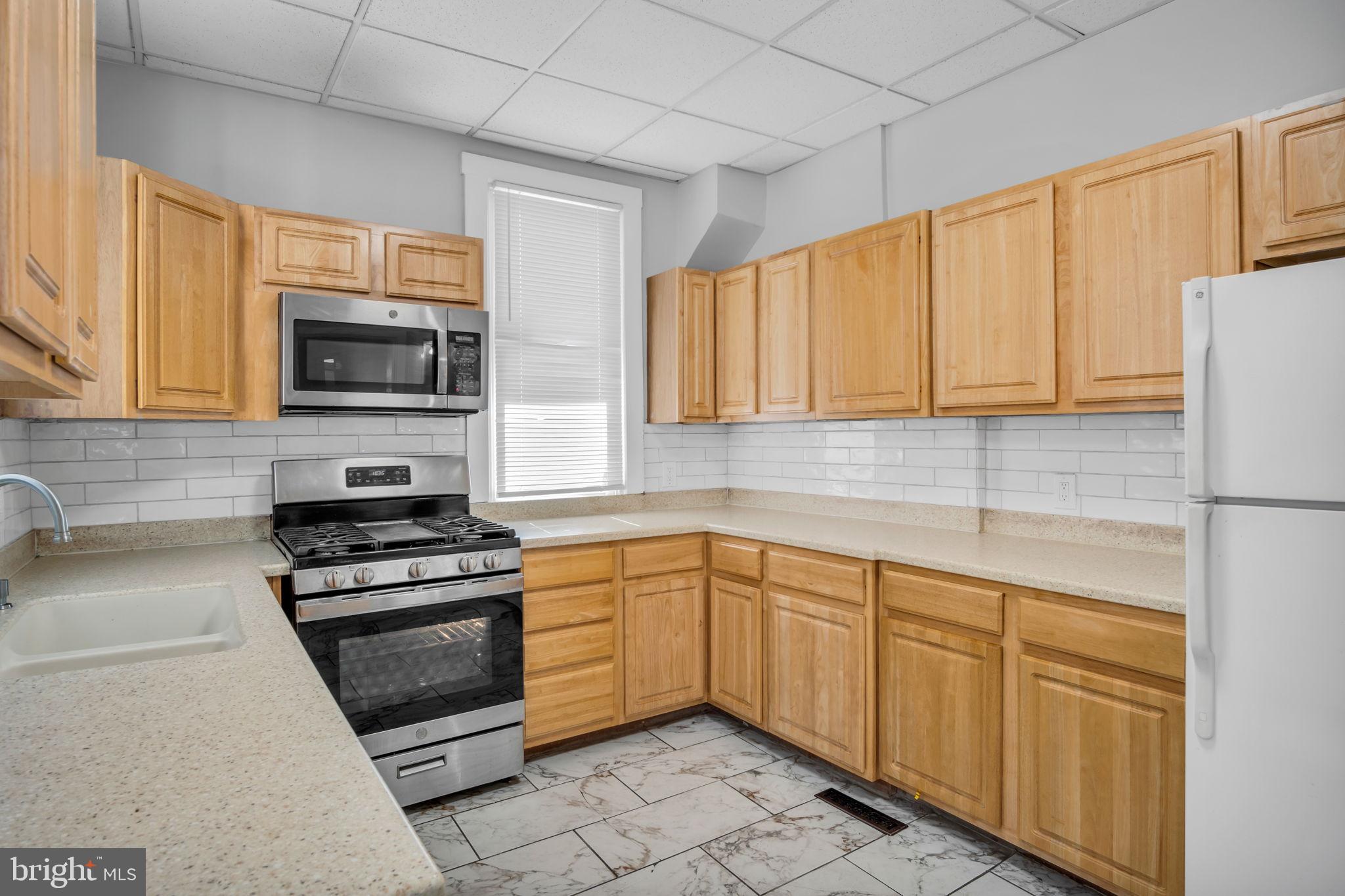 211 Cumberland Street Harrisburg, PA 17102 - Photo 16 of 26 a kitchen with cabinets stainless steel appliances and a window